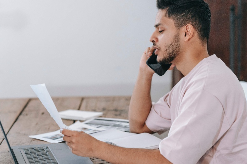 A recruiter offering a job to a candidate on call while looking at his/her application